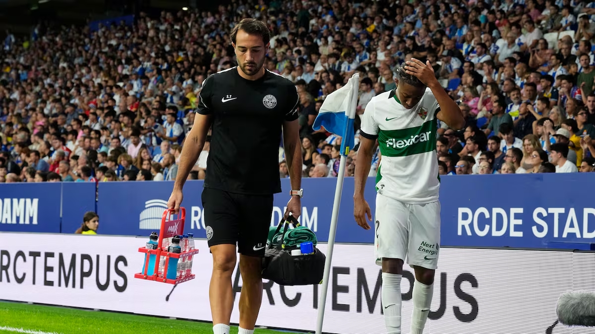 Jugador y personal médico en la banda del campo